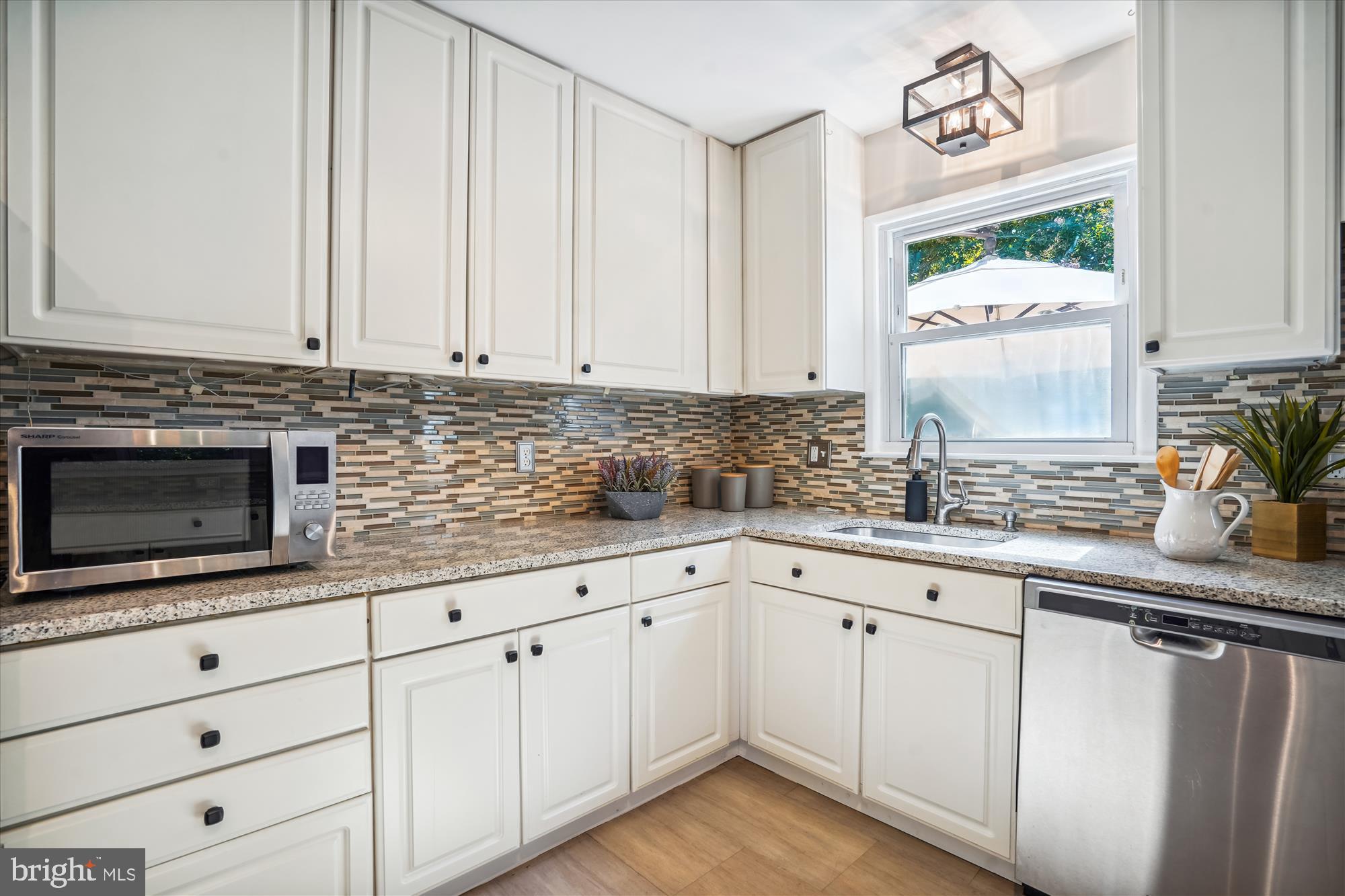 5742 Rolling Road Burke, VA 22015 - Photo 26 of 53 a kitchen with granite countertop white cabinets white appliances and a sink