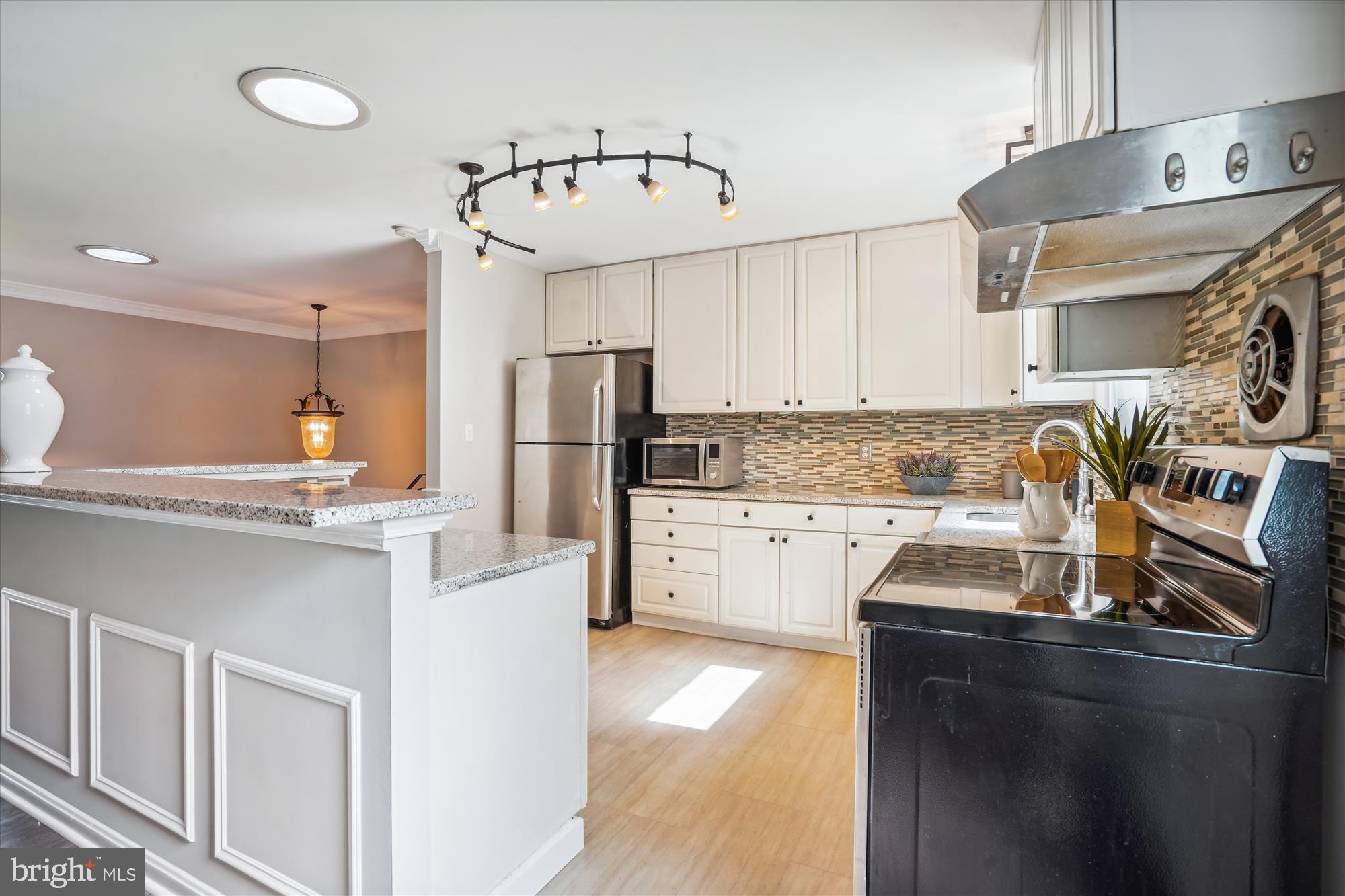 5742 Rolling Road Burke, VA 22015 - Photo 27 of 53 a kitchen with stainless steel appliances a sink a stove a refrigerator cabinets and a counter top space