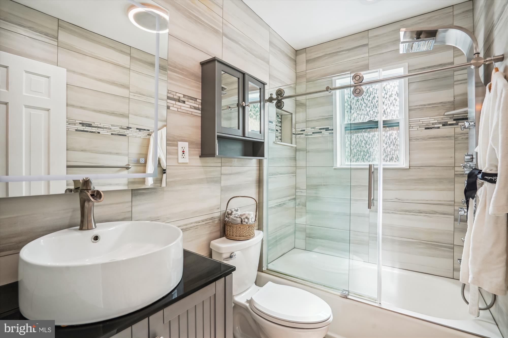 5742 Rolling Road Burke, VA 22015 - Photo 45 of 53 a bathroom with a sink toilet a mirror and shower