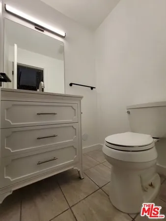a bathroom with a toilet and a mirror