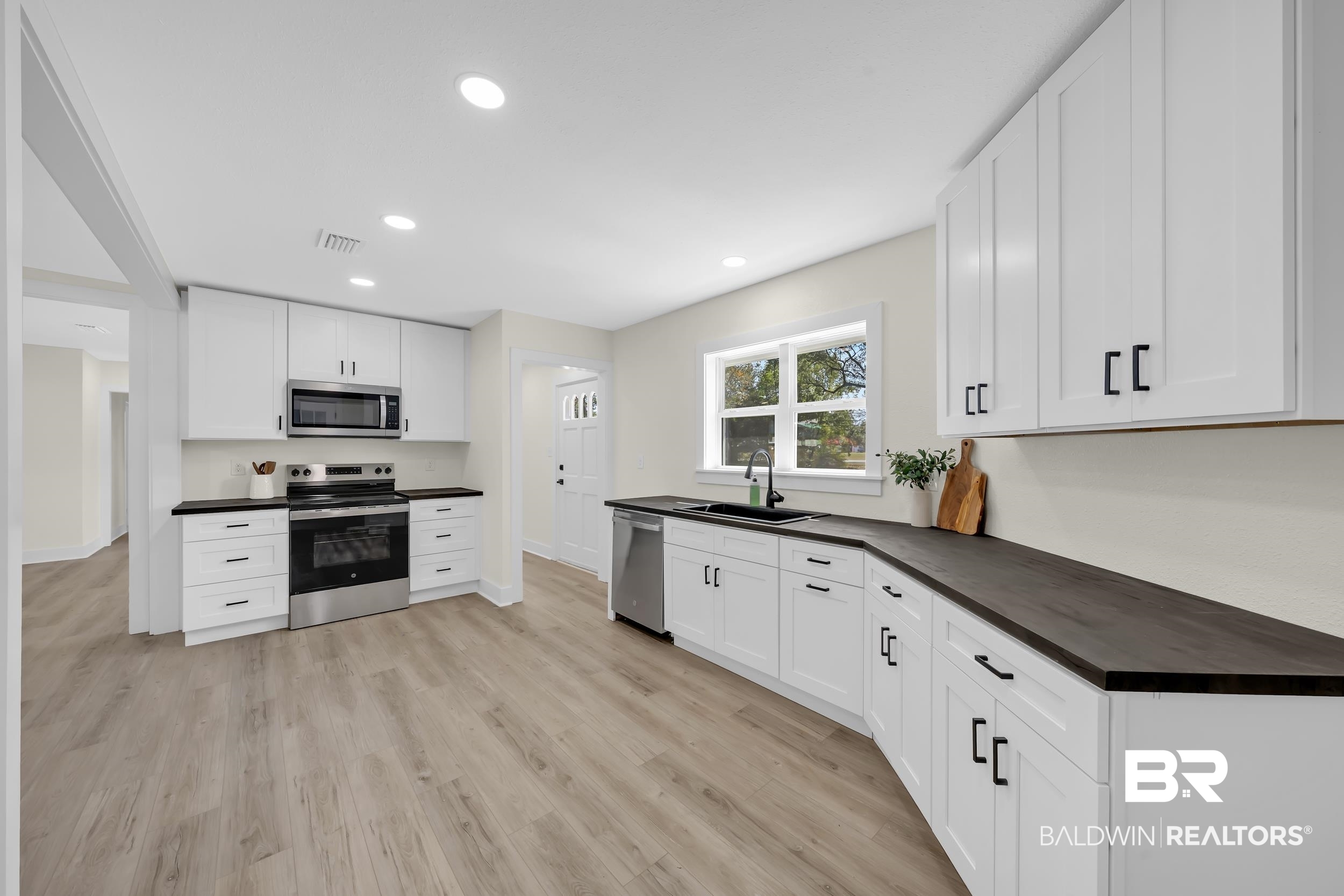 1409 Altair Lane Mobile, AL 36693 - Photo 8 of 23 Kitchen with stainless steel appliances, white cabinetry, dark countertops, light wood finished floors, and recessed lighting