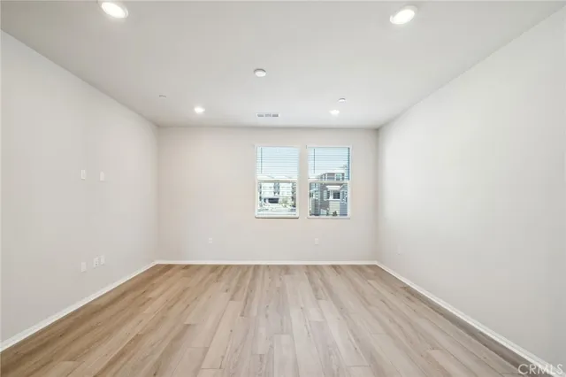 a view of a hallway with wooden floor and closet