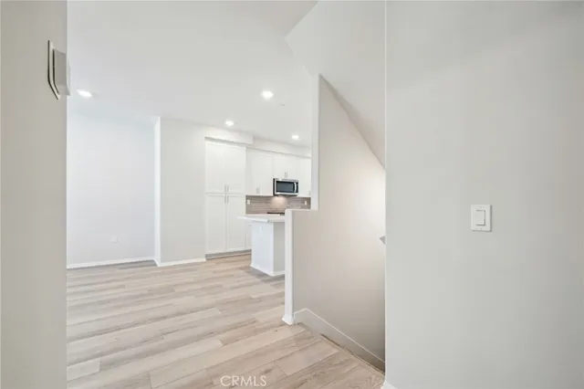 a view of kitchen with kitchen island stainless steel appliances wooden floor and window
