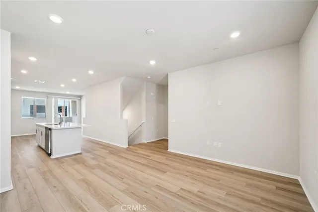 a kitchen with a refrigerator and wooden floor