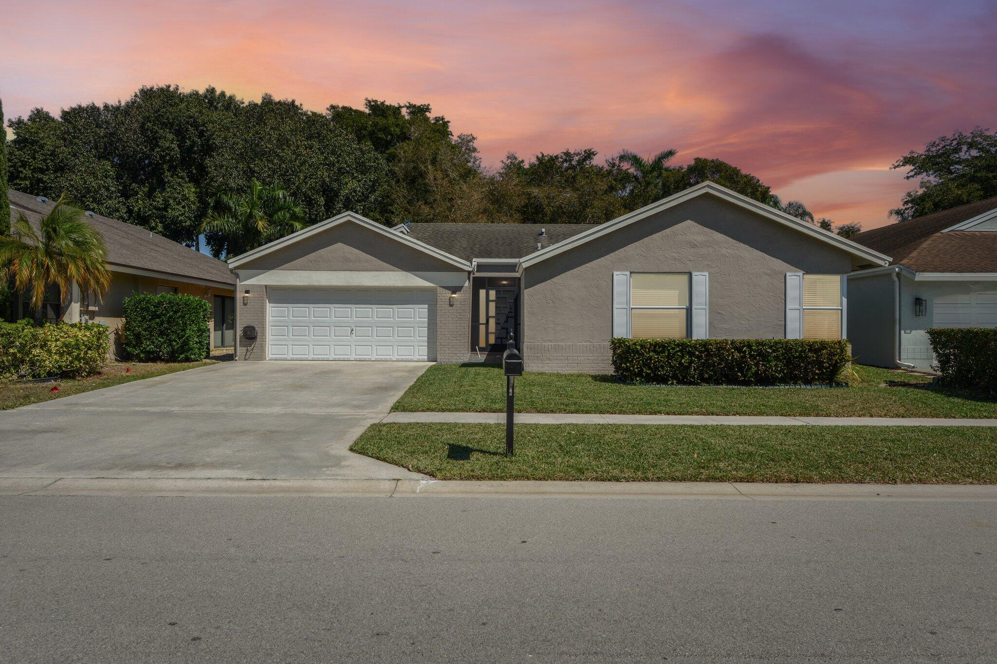21024 Country Creek Drive Boca Raton, FL 33428 - Photo 1 of 59 a front view of a house with a yard