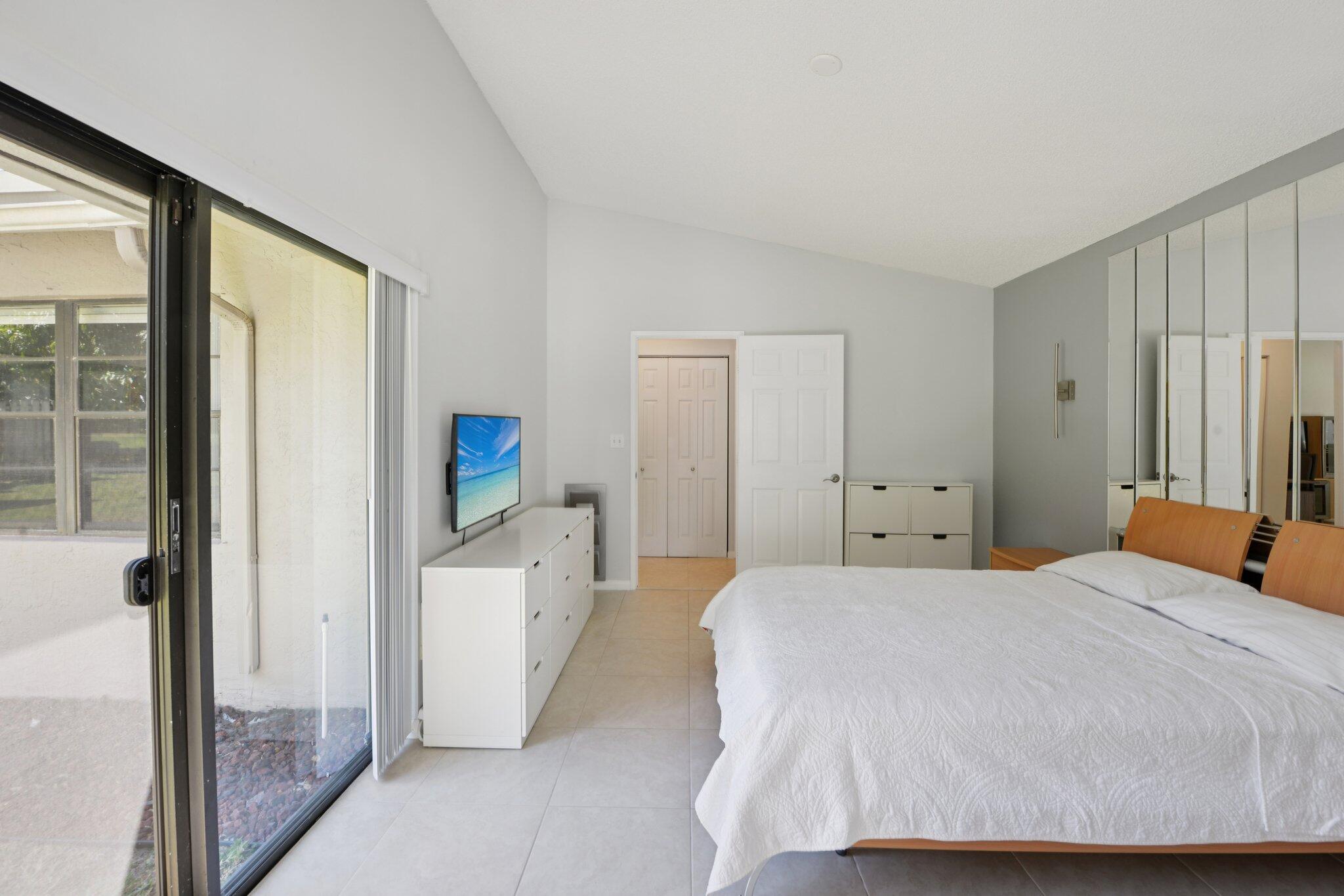 21024 Country Creek Drive Boca Raton, FL 33428 - Photo 17 of 59 a bedroom with a large white bed and a large window
