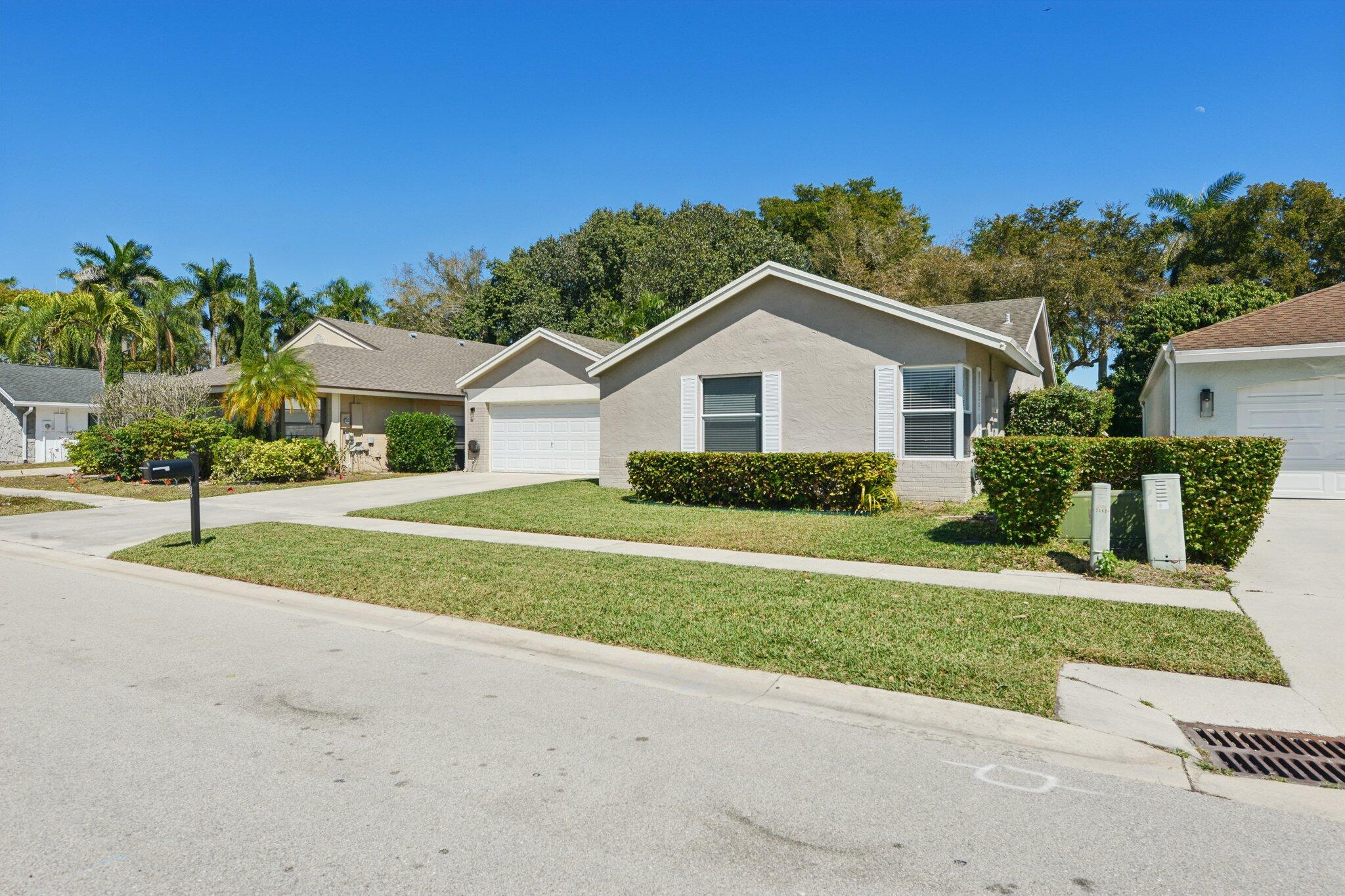 21024 Country Creek Drive Boca Raton, FL 33428 - Photo 2 of 59 a front view of a house with a yard