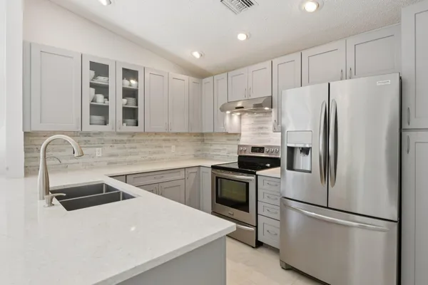 a kitchen with stainless steel appliances a refrigerator sink and stove