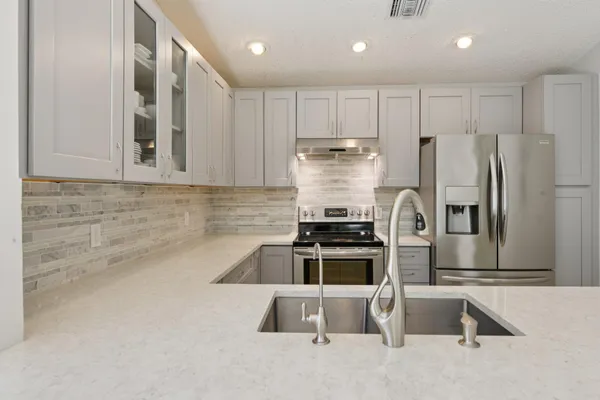 a kitchen with stainless steel appliances granite countertop a refrigerator and a stove