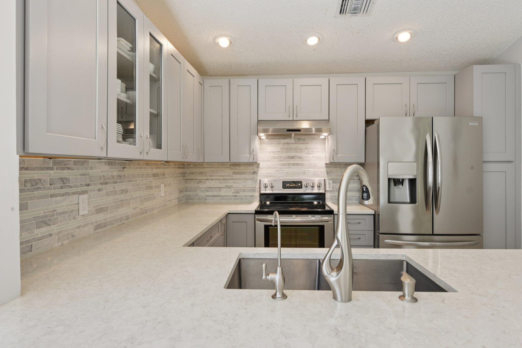 21024 Country Creek Drive Boca Raton, FL 33428 - Photo 5 of 59 a kitchen with stainless steel appliances granite countertop a refrigerator and a stove