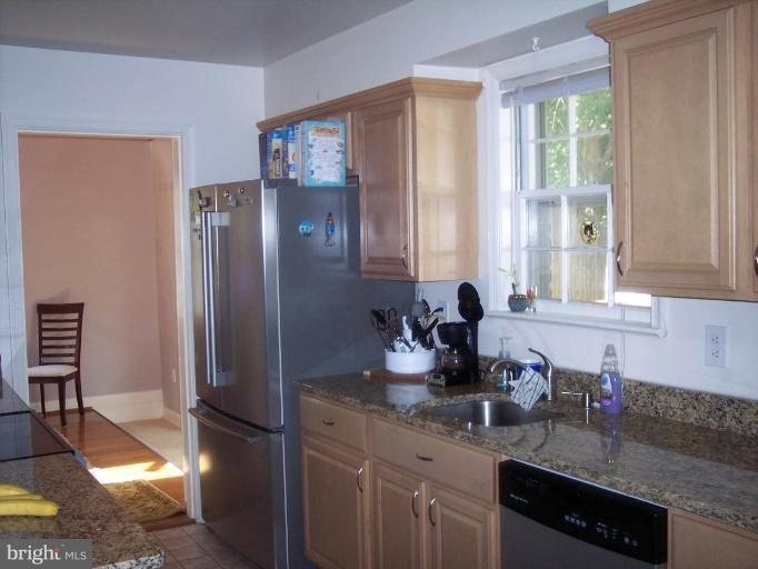 6209 Redwing Road Bethesda, MD 20817 - Photo 14 of 25 a kitchen with granite countertop a refrigerator and a sink