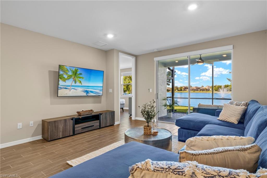 14644 Edgewater Circle Naples, FL 34114 - Photo 2 of 37 a living room with furniture and a flat screen tv