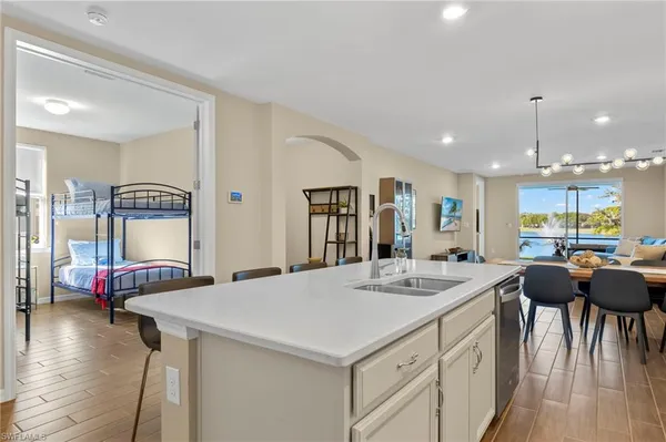 a kitchen with stainless steel appliances kitchen island granite countertop a sink and a refrigerator