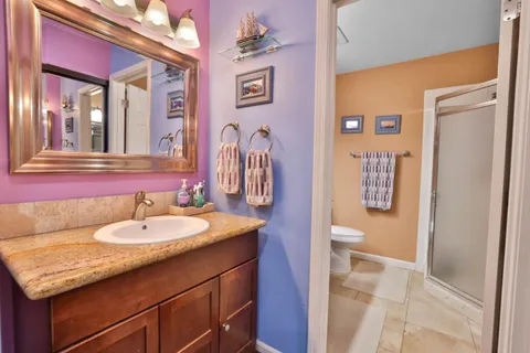 a bathroom with a granite countertop sink a mirror and a shower