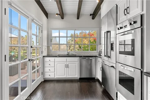 a kitchen with stainless steel appliances white cabinets and wooden floors