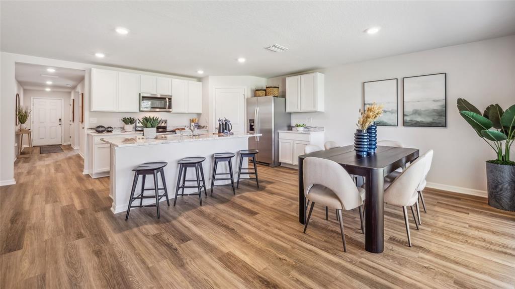 10712 Gentle Current Way Parrish, FL 34219 - Photo 7 of 20 a dining room with furniture and wooden floor