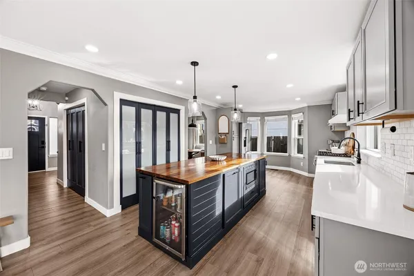 a large kitchen with stainless steel appliances granite countertop a large counter top and a wooden floors