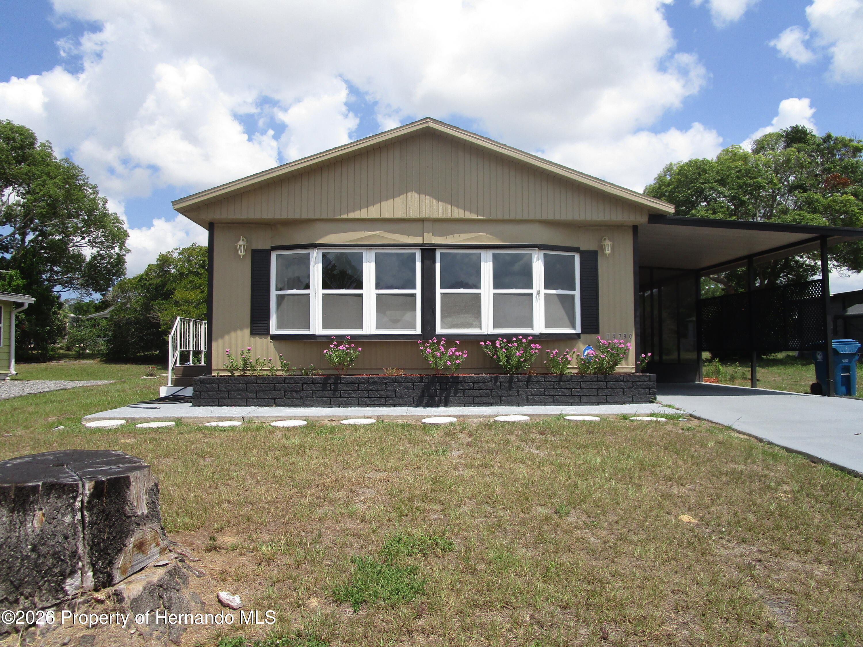 14790 Rialto Avenue, Unit 3 Brooksville, FL 34613 - Photo 1 of 15 a front view of a house with a yard