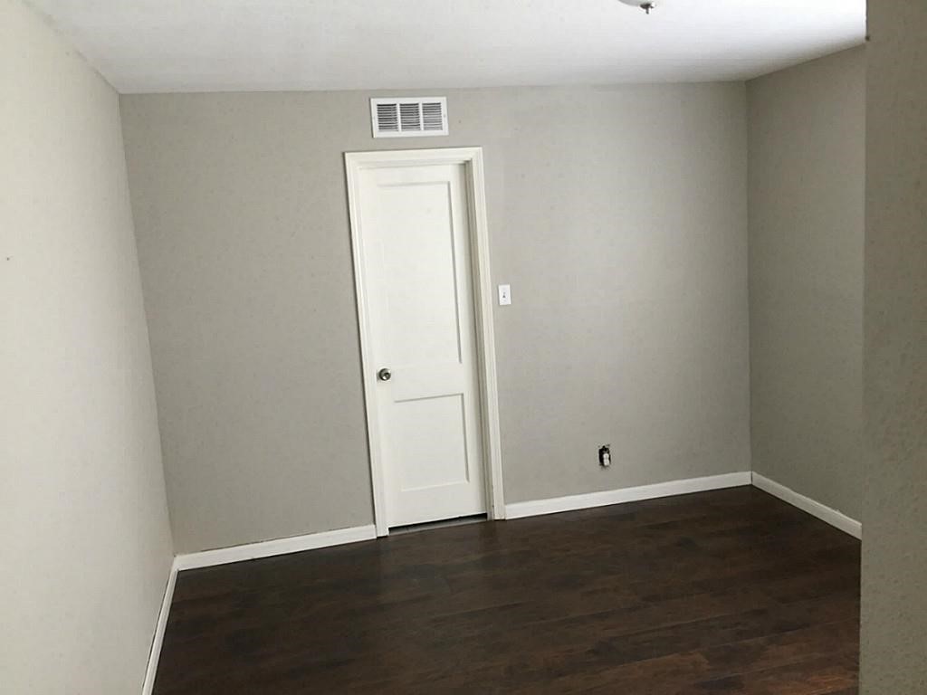 3502 Rosedale Street Houston, TX 77004 - Photo 9 of 17 Room with neutral walls and rich, dark hardwood flooring, offering a clean slate for personalization.