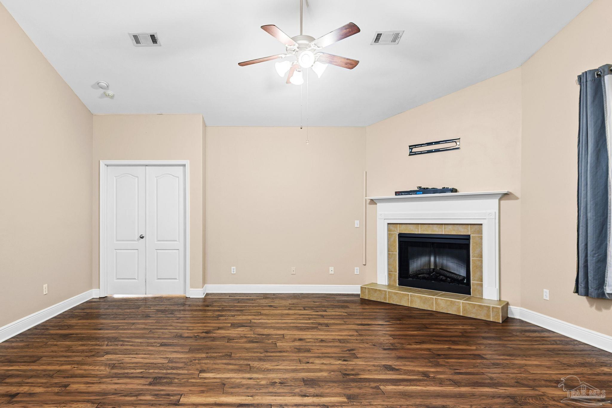 1007 Patriot Place Pensacola, FL 32534 - Photo 9 of 40 a view of an empty room with chandelier fan and wooden floor