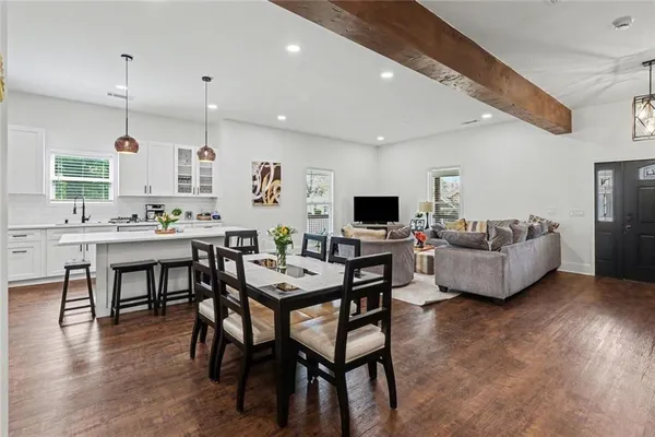 a dining room with stainless steel appliances kitchen island granite countertop a dining table chairs and view living room