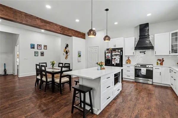 a kitchen with stainless steel appliances cabinets a dining table and chairs