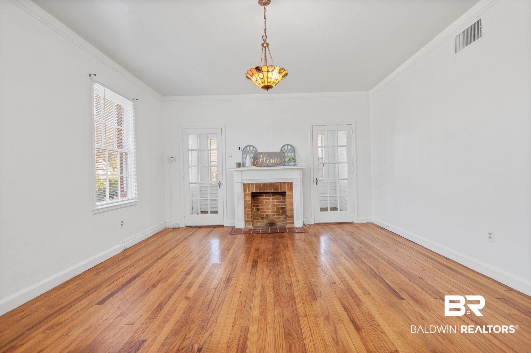 1707 Church Street Mobile, AL 36604 - Photo 5 of 43 Unfurnished living room with baseboards, visible vents, and wood-type flooring