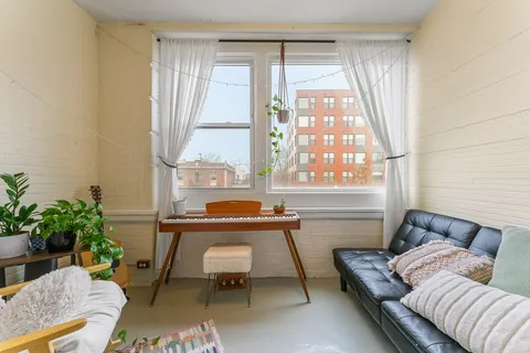 a view of room with window and refrigerator