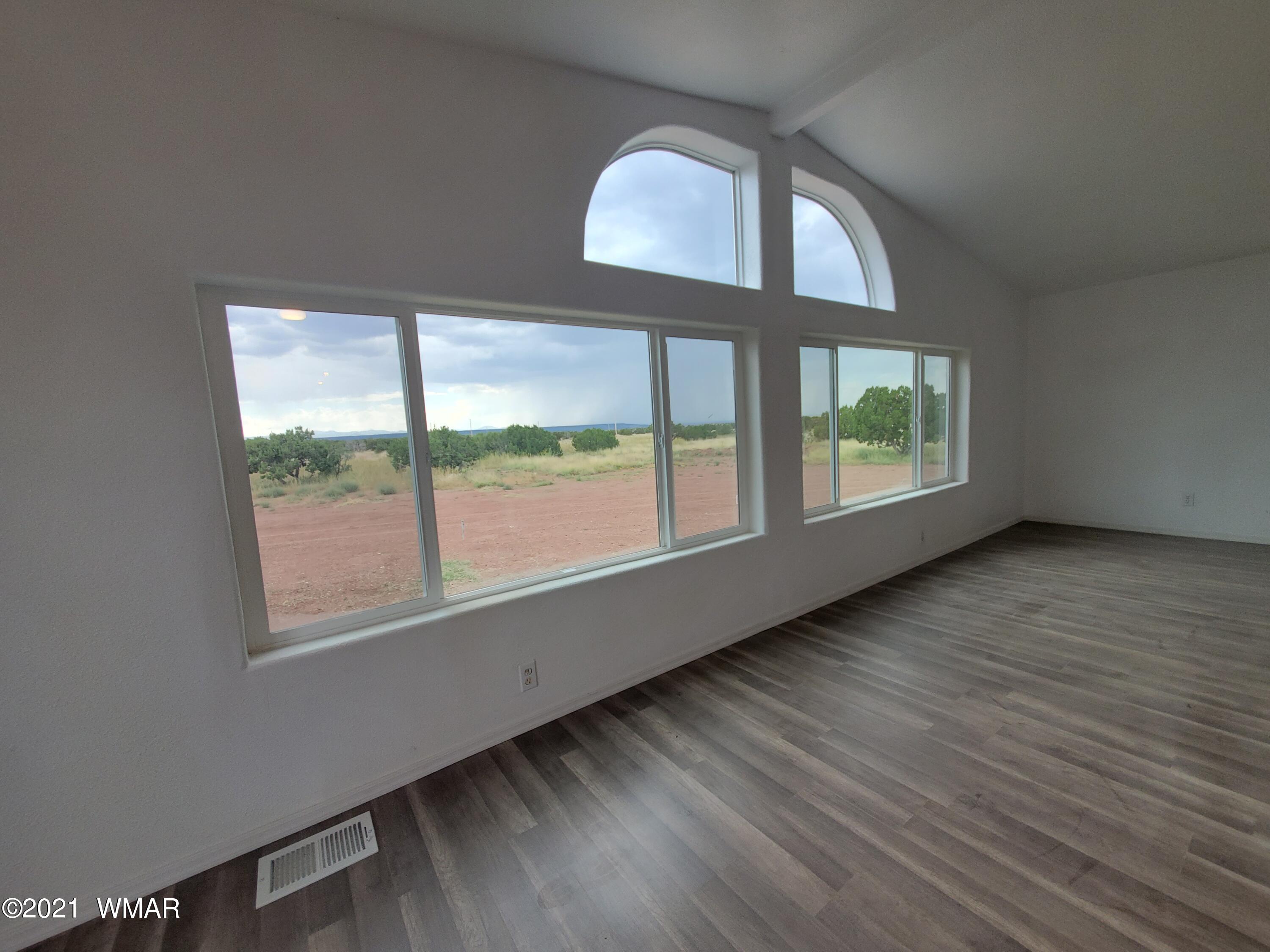 181 River Spings Ranch St. Johns, AZ 85936 - Photo 17 of 60 an empty room with wooden floor and windows