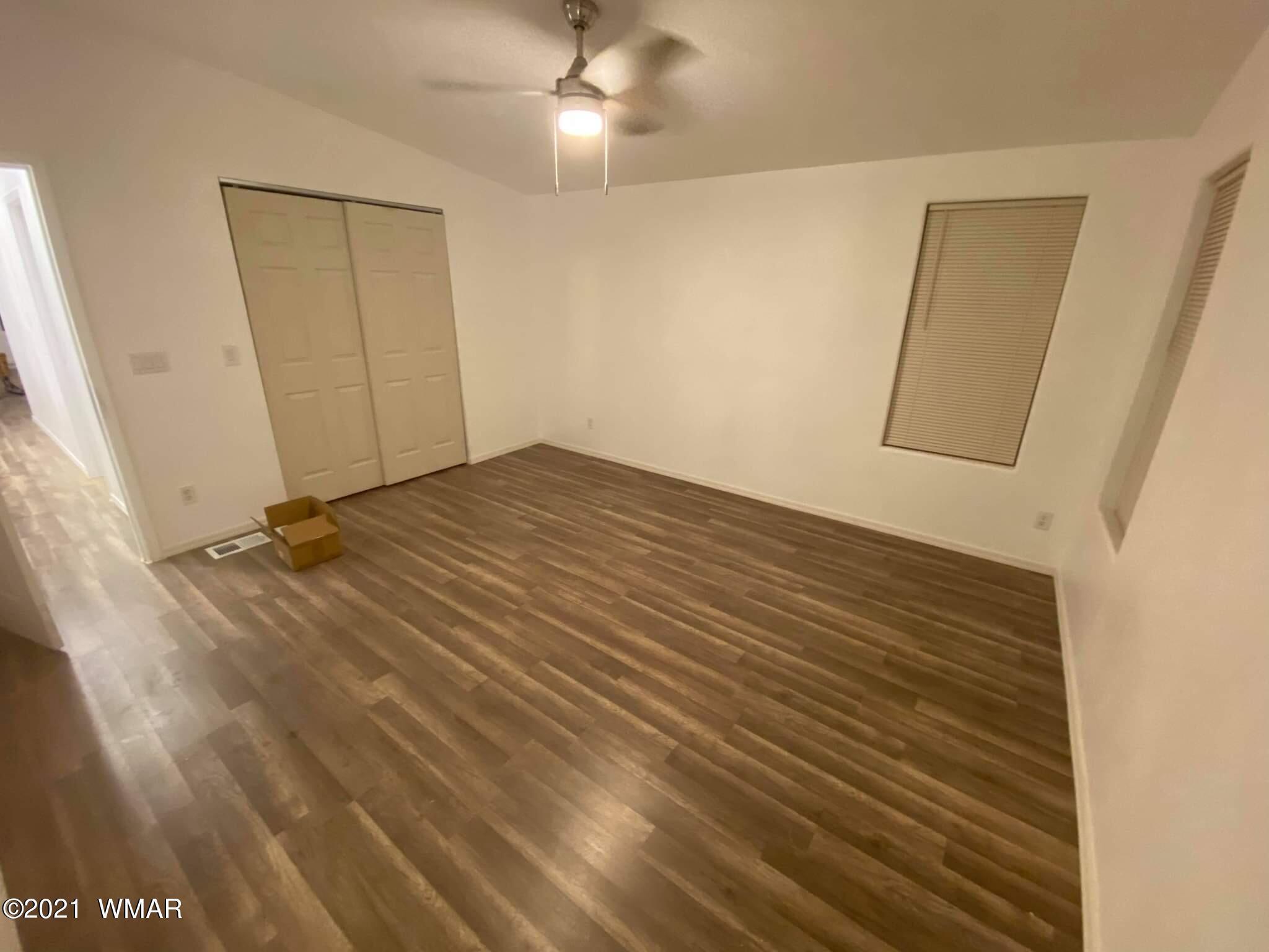 181 River Spings Ranch St. Johns, AZ 85936 - Photo 22 of 60 a view of a room with wooden floor and a ceiling fan