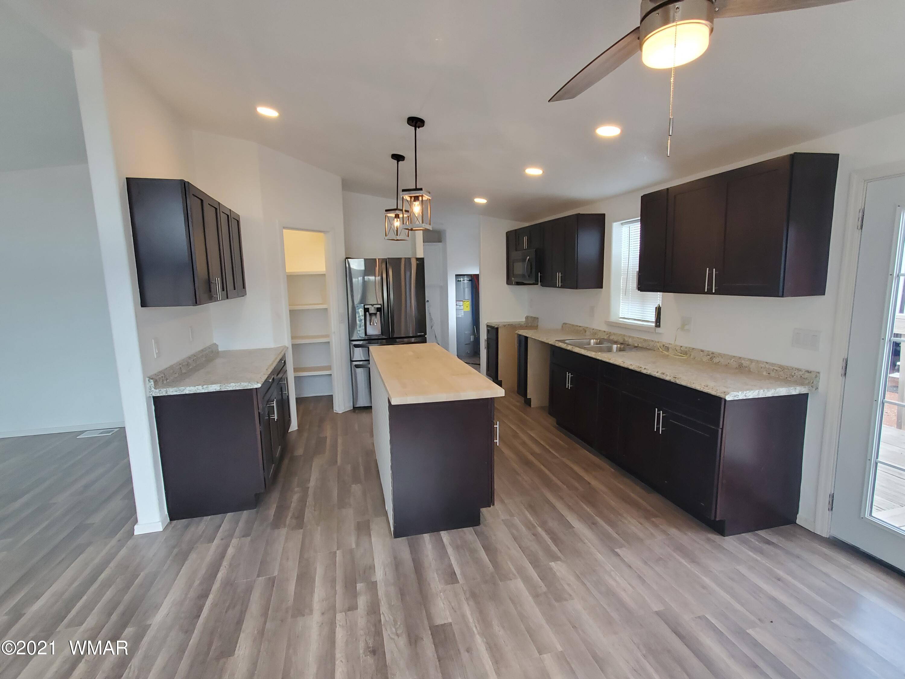 181 River Spings Ranch St. Johns, AZ 85936 - Photo 6 of 60 a large kitchen with stainless steel appliances kitchen island granite countertop a large stove a sink dishwasher and a microwave oven with large wooden cabinets
