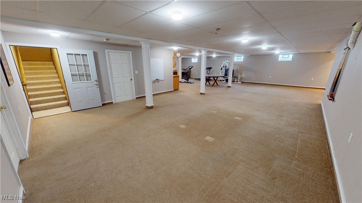 10323 Smith Road Litchfield, OH 44253 - Photo 34 of 50 Basement featuring baseboards, a drop ceiling, stairway, and light carpet