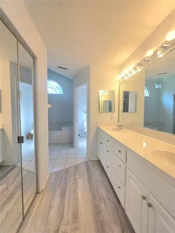 a spacious bathroom with a granite countertop sink mirror and a shower