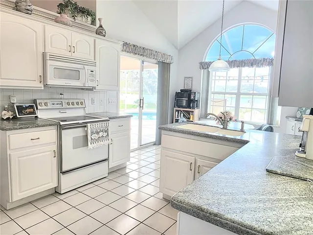 a kitchen with stainless steel appliances granite countertop a stove a sink and a granite counter tops