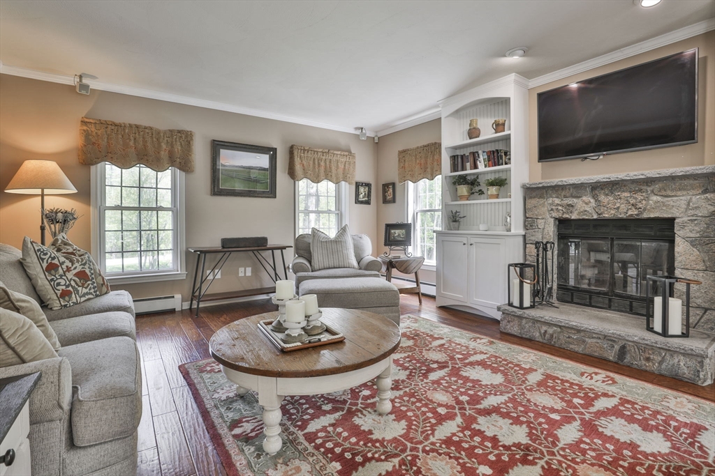 32 Glance Road Windham, NH 03087 - Photo 19 of 42 a living room with furniture a flat screen tv and a fireplace