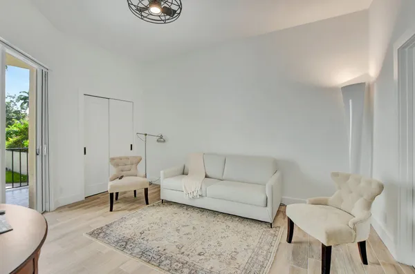 a spacious bedroom with a bed and a lamp on table