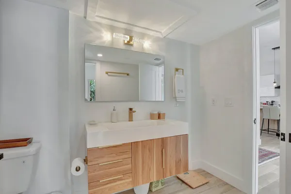a bathroom with a sink a mirror and a toilet