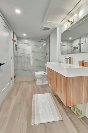 a bathroom with a sink a toilet and a mirror