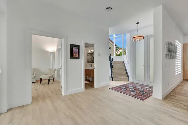 a kitchen with a sink dishwasher stove and white cabinets with wooden floor