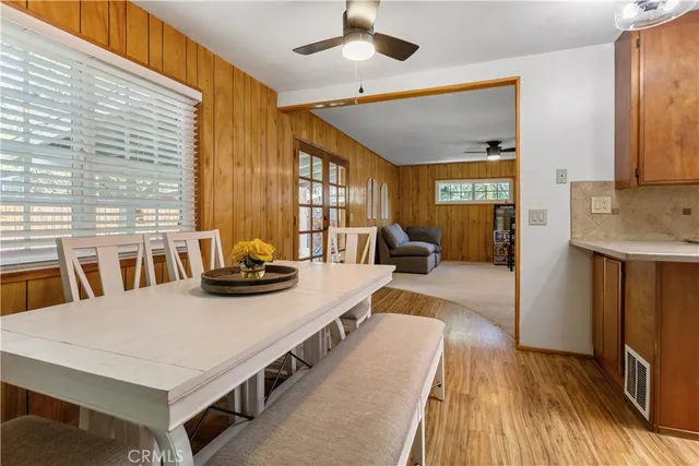 a living room with stainless steel appliances furniture a rug and a large window
