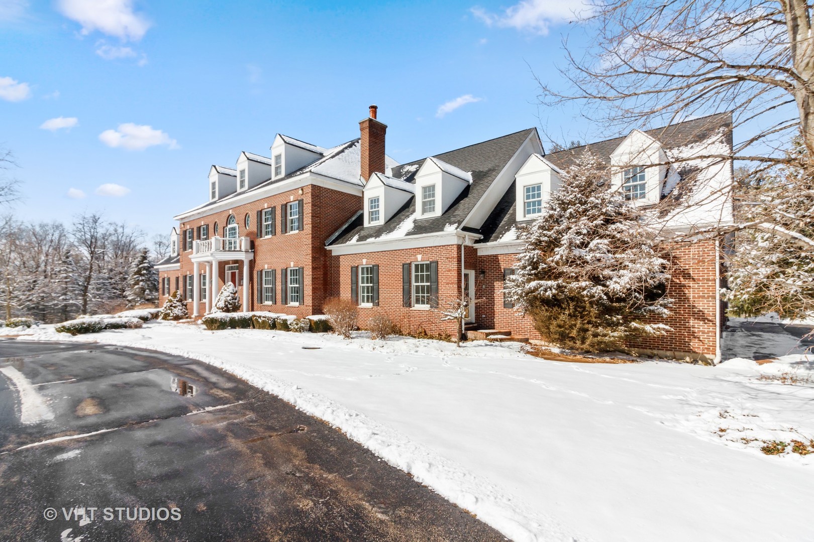 a view of a house with a yard covered in snow