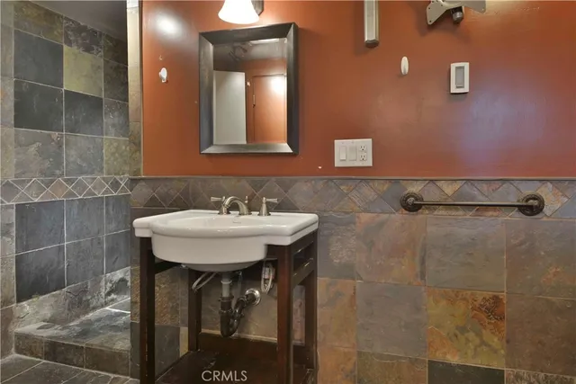 a bathroom with a sink shower and a mirror