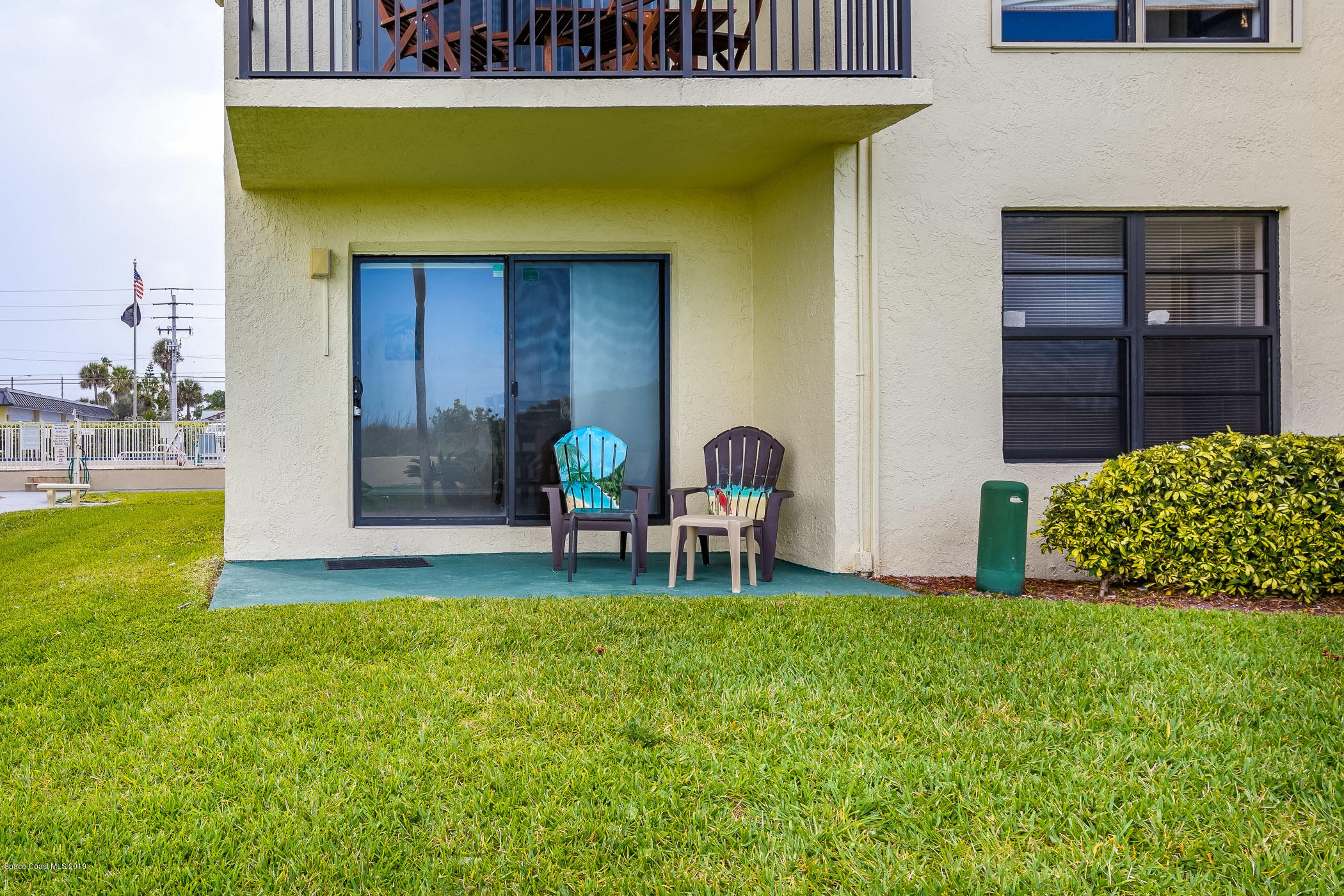 4570 Ocean Beach Boulevard, Unit 106 Cocoa Beach, FL 32931 - Photo 15 of 39 a view of a chair and table in back yard of the house