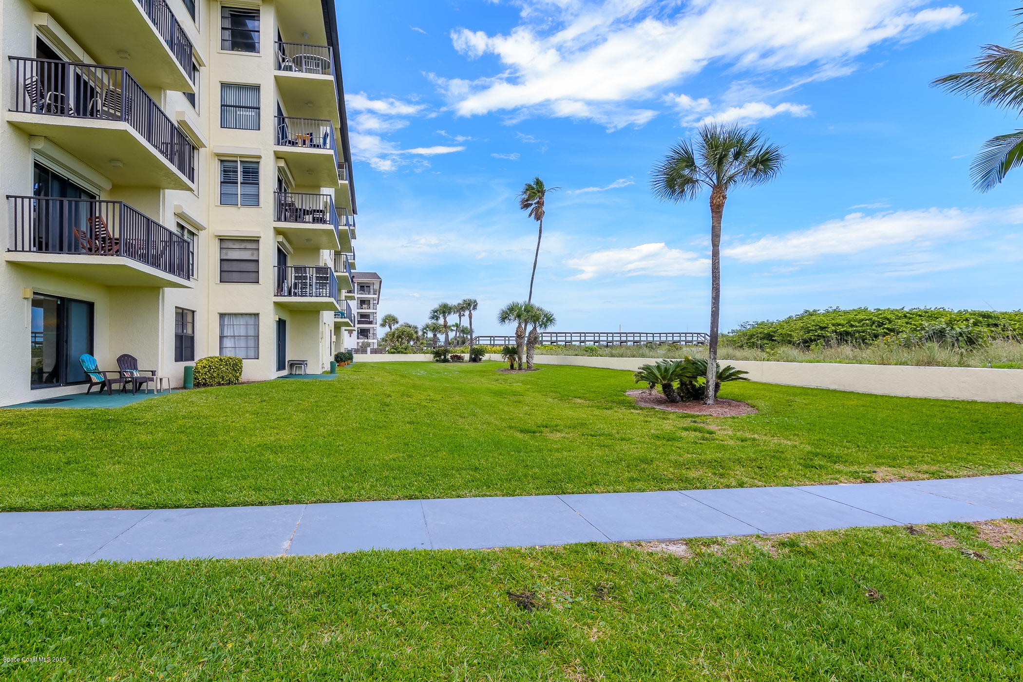 4570 Ocean Beach Boulevard, Unit 106 Cocoa Beach, FL 32931 - Photo 17 of 39 a view of a big room with a big yard and plants