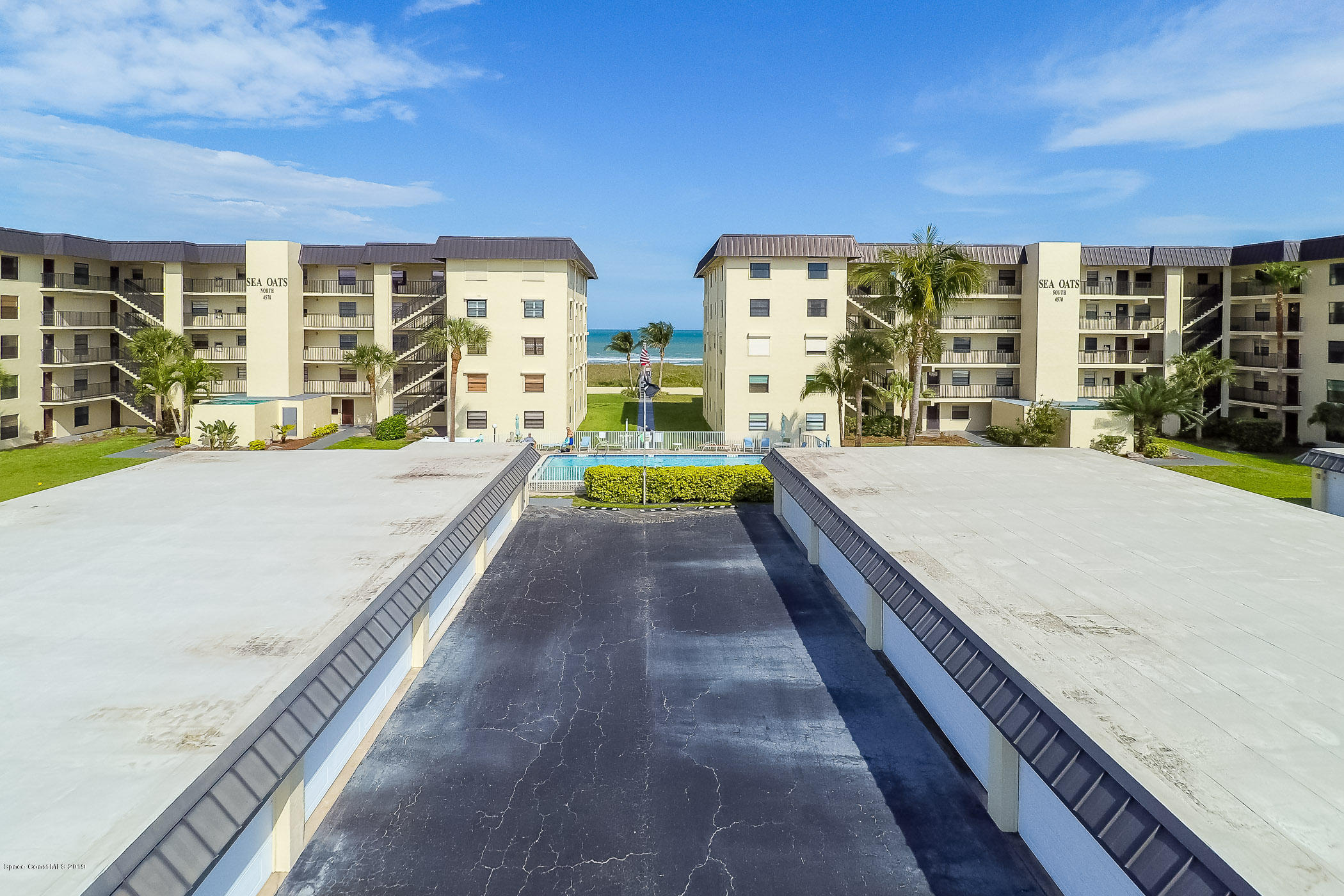 4570 Ocean Beach Boulevard, Unit 106 Cocoa Beach, FL 32931 - Photo 22 of 39 a swimming pool with outdoor seating