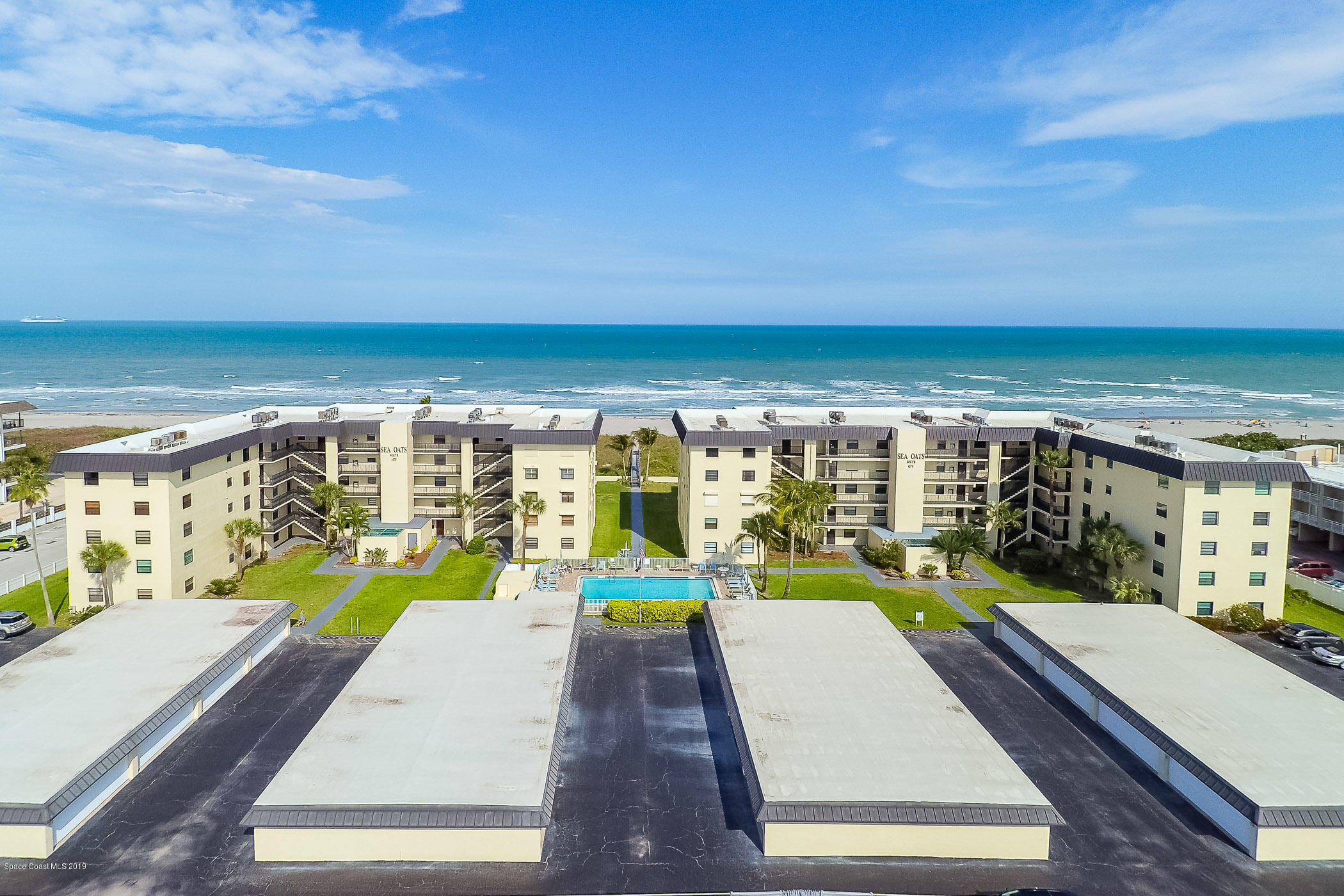 4570 Ocean Beach Boulevard, Unit 106 Cocoa Beach, FL 32931 - Photo 23 of 39 swimming pool view with a couple of large trees