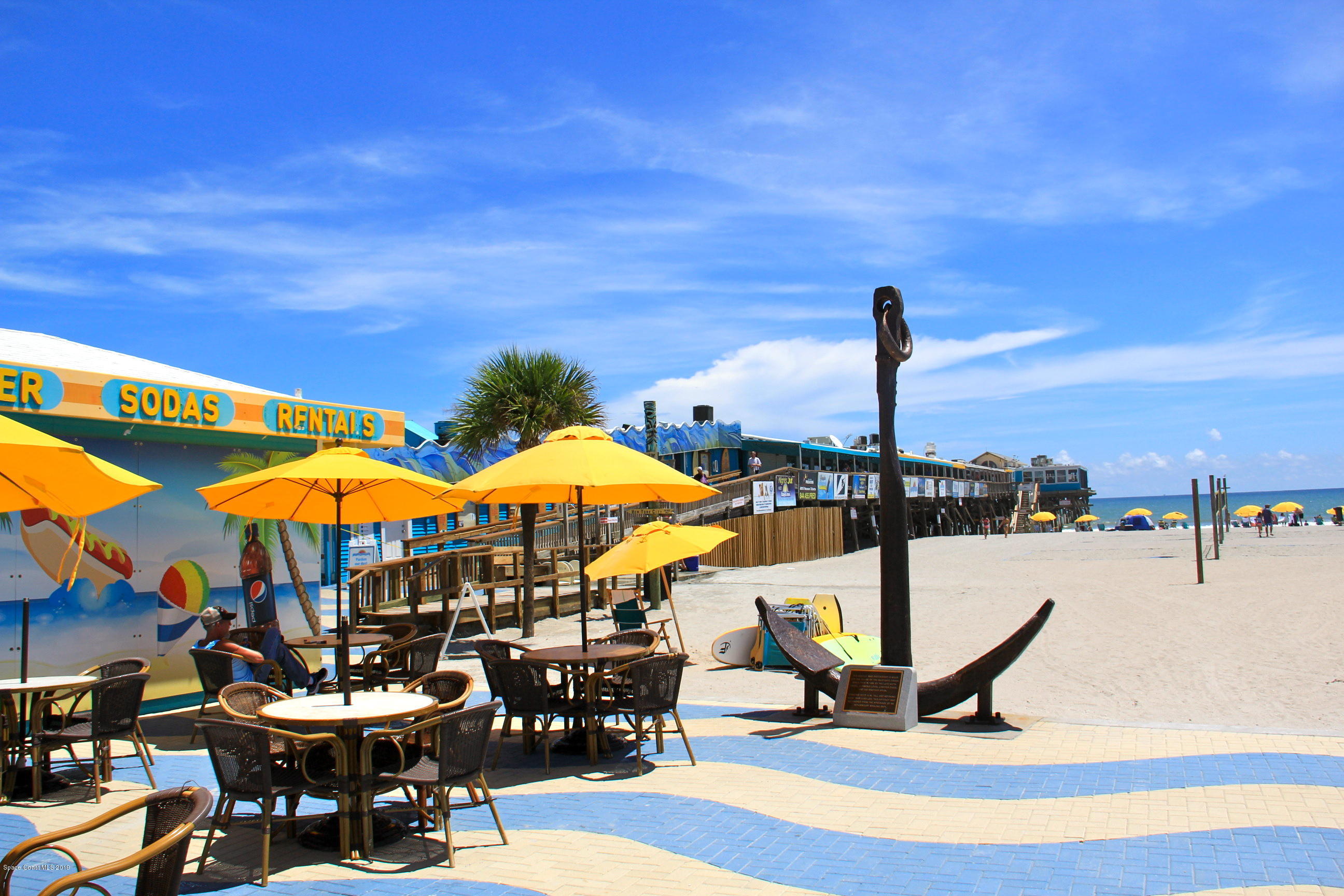 4570 Ocean Beach Boulevard, Unit 106 Cocoa Beach, FL 32931 - Photo 33 of 39 a view of a swimming pool with lawn chairs under an umbrella