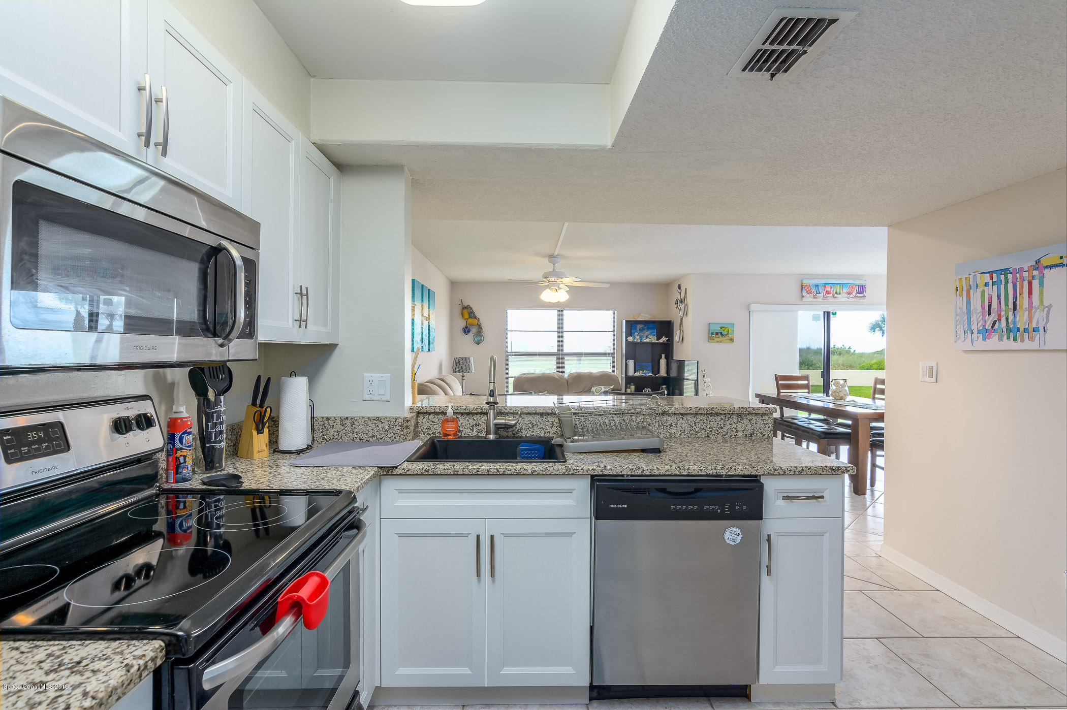4570 Ocean Beach Boulevard, Unit 106 Cocoa Beach, FL 32931 - Photo 6 of 39 a kitchen with stainless steel appliances granite countertop a stove and a sink