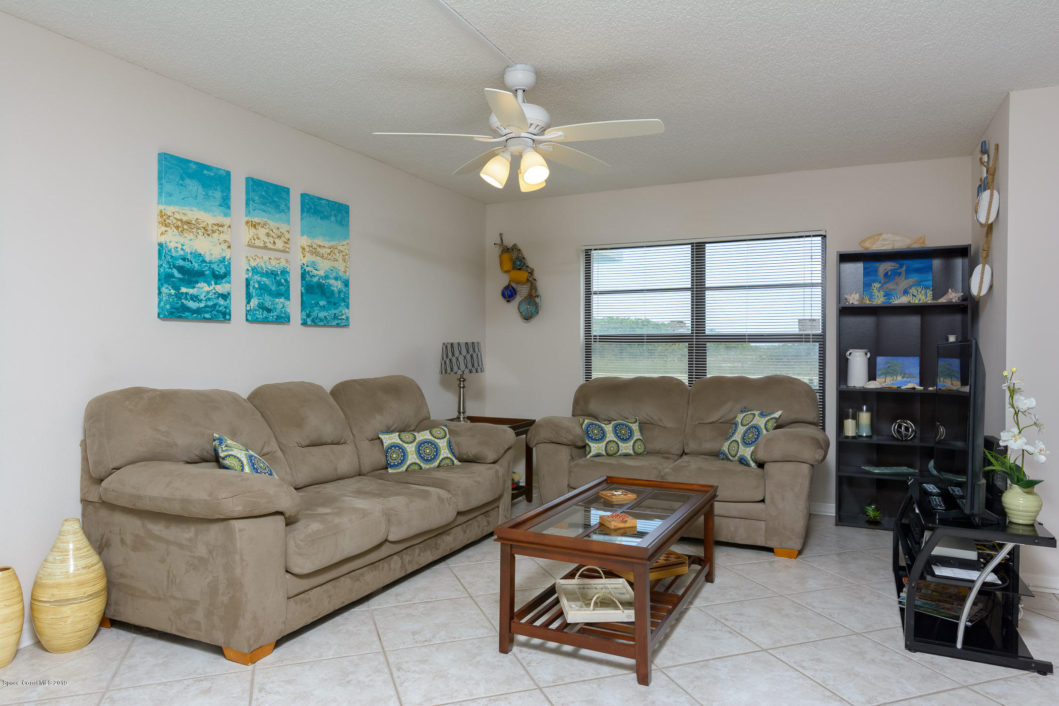 4570 Ocean Beach Boulevard, Unit 106 Cocoa Beach, FL 32931 - Photo 7 of 39 a living room with furniture and a flat screen tv