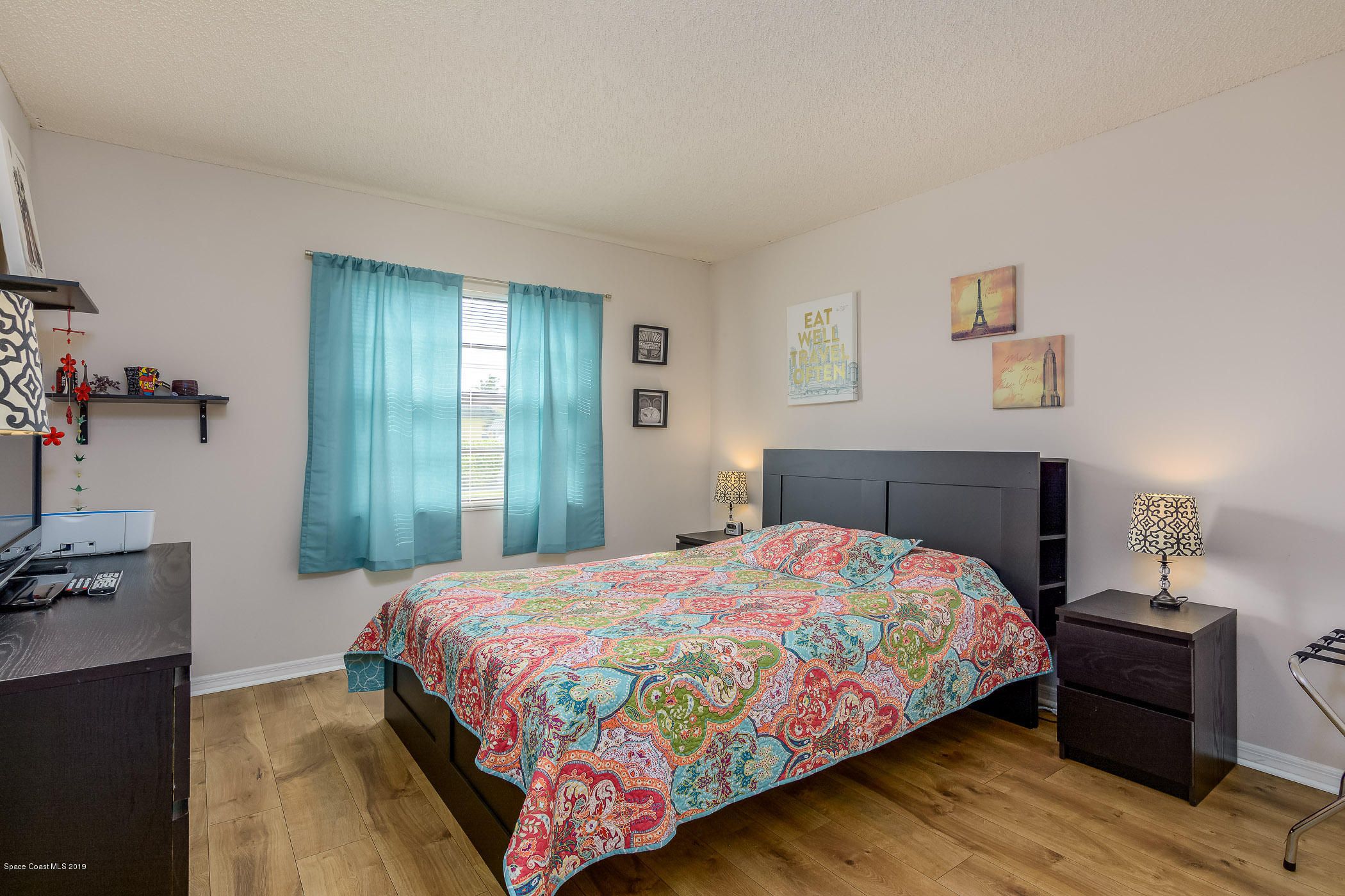 4570 Ocean Beach Boulevard, Unit 106 Cocoa Beach, FL 32931 - Photo 8 of 39 a bedroom with a bed and wooden floor